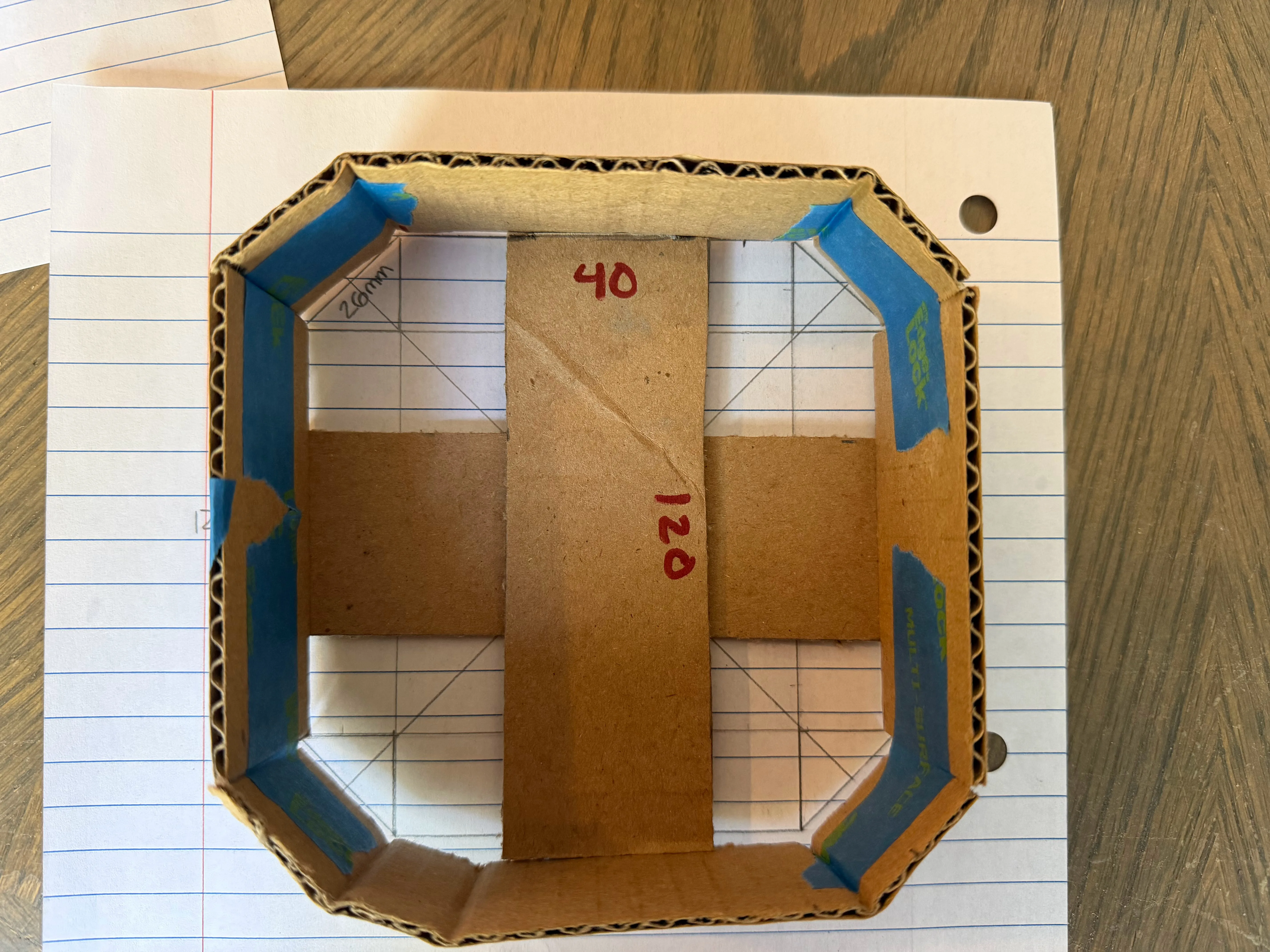 Top-down view of the taped cardboard mockup showing an internal cross-brace strip for mounting the stepper motor